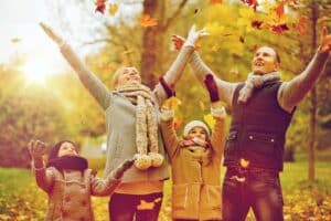 Orlando Home Inspectors a family throwing leaves and enjoying the autumn season