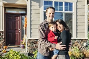 Orlando Home Inspectors couple with their son standing in front of their house